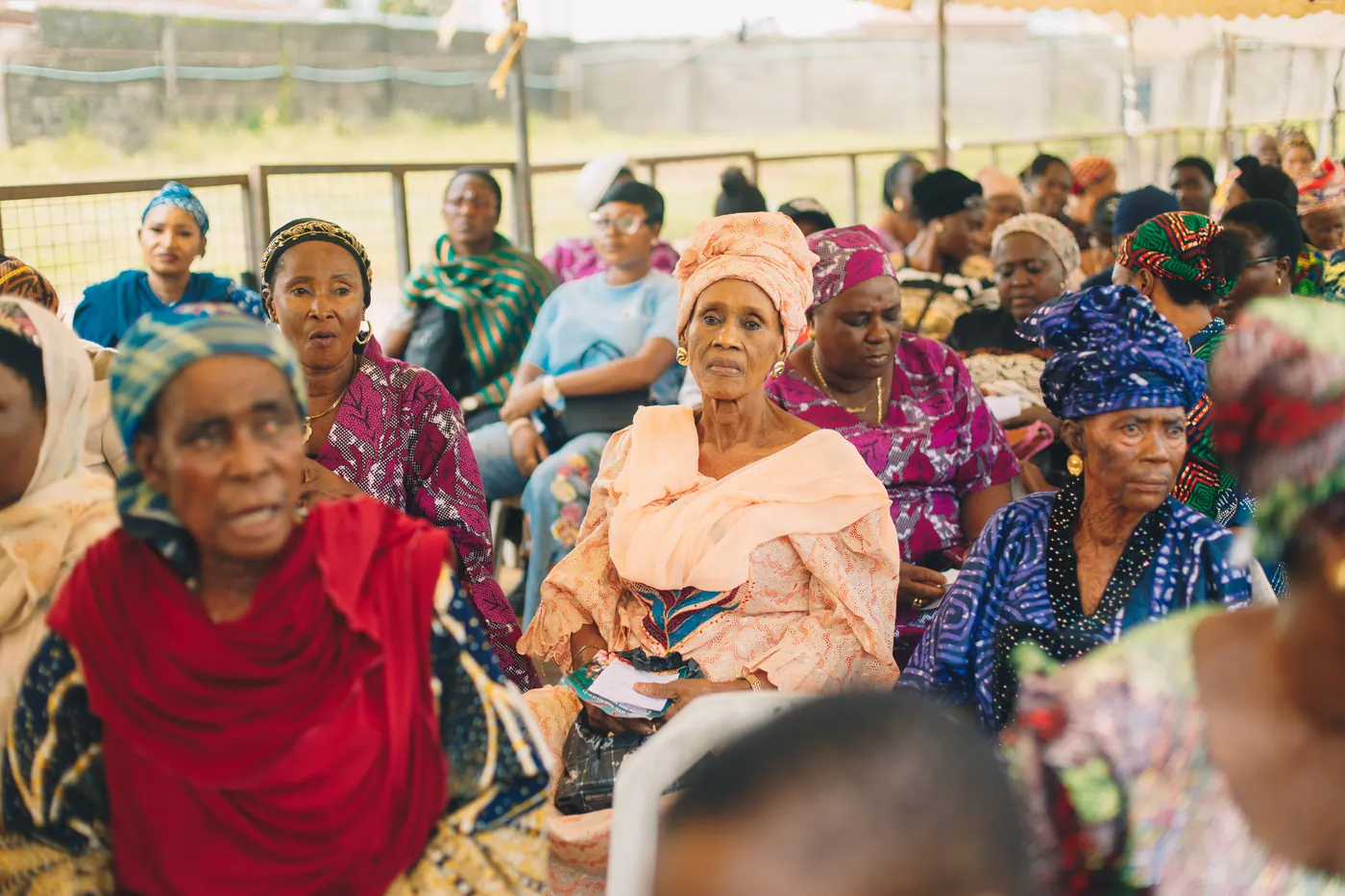 Elderly women seated together at a Smiley Caring Foundation community event.