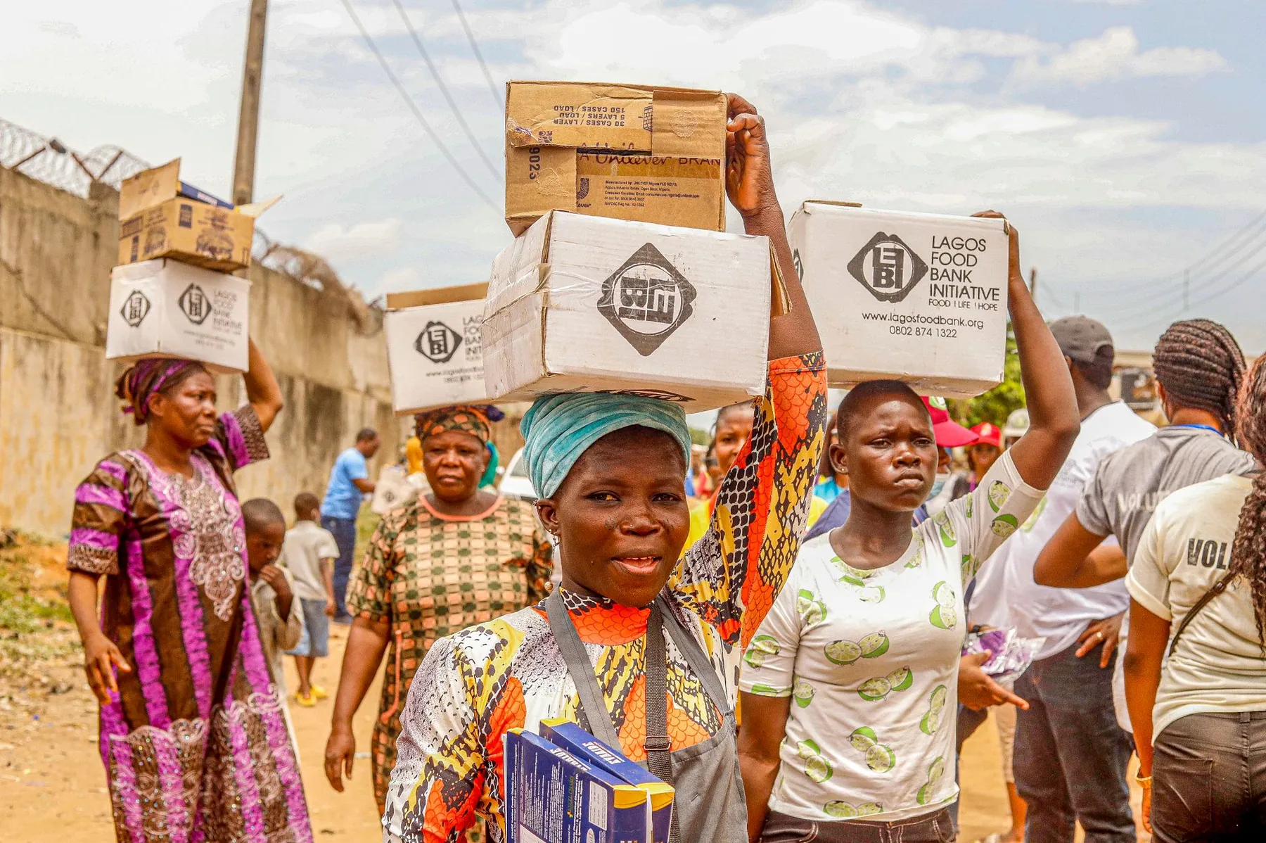 Volunteers carrying relief boxes at a community distribution event in Lagos.