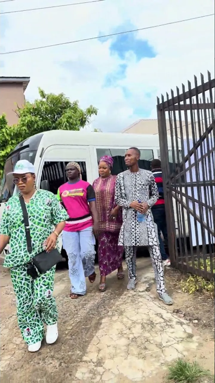 Residents walking through a gate towards the Smiley Caring Foundation outreach in Mushin.